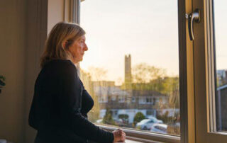 an older woman looking out of a window