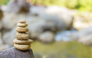 zen rocks stacked next to a small pond